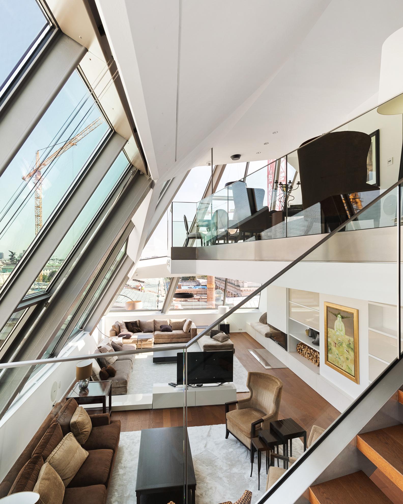 Luxuriöse Maisonette-Wohnung mit großen, schrägen Fenstern und Treppe.